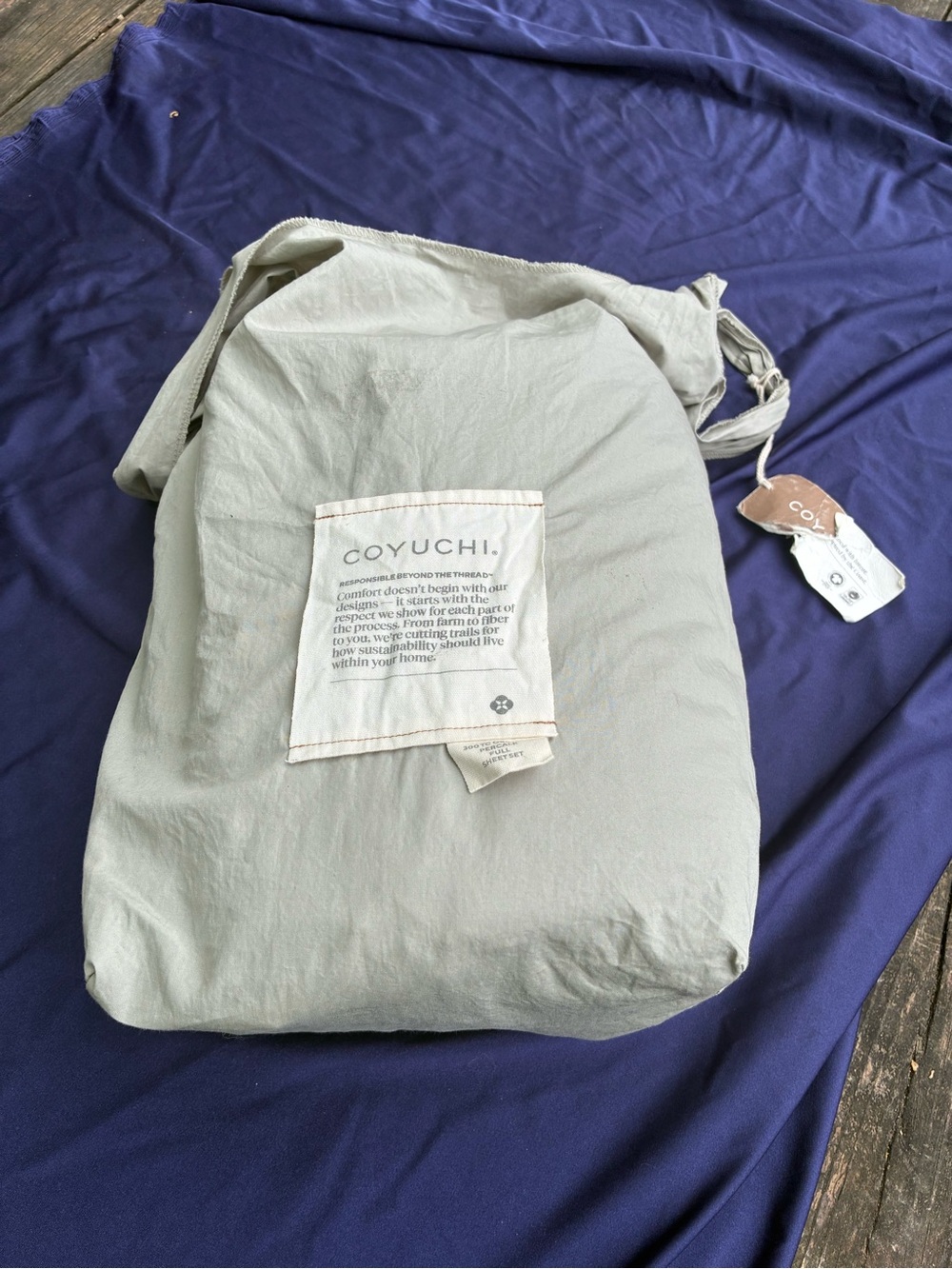 Coyuchi Neutral Gray Bedding Bag with Deep Blue Sheet